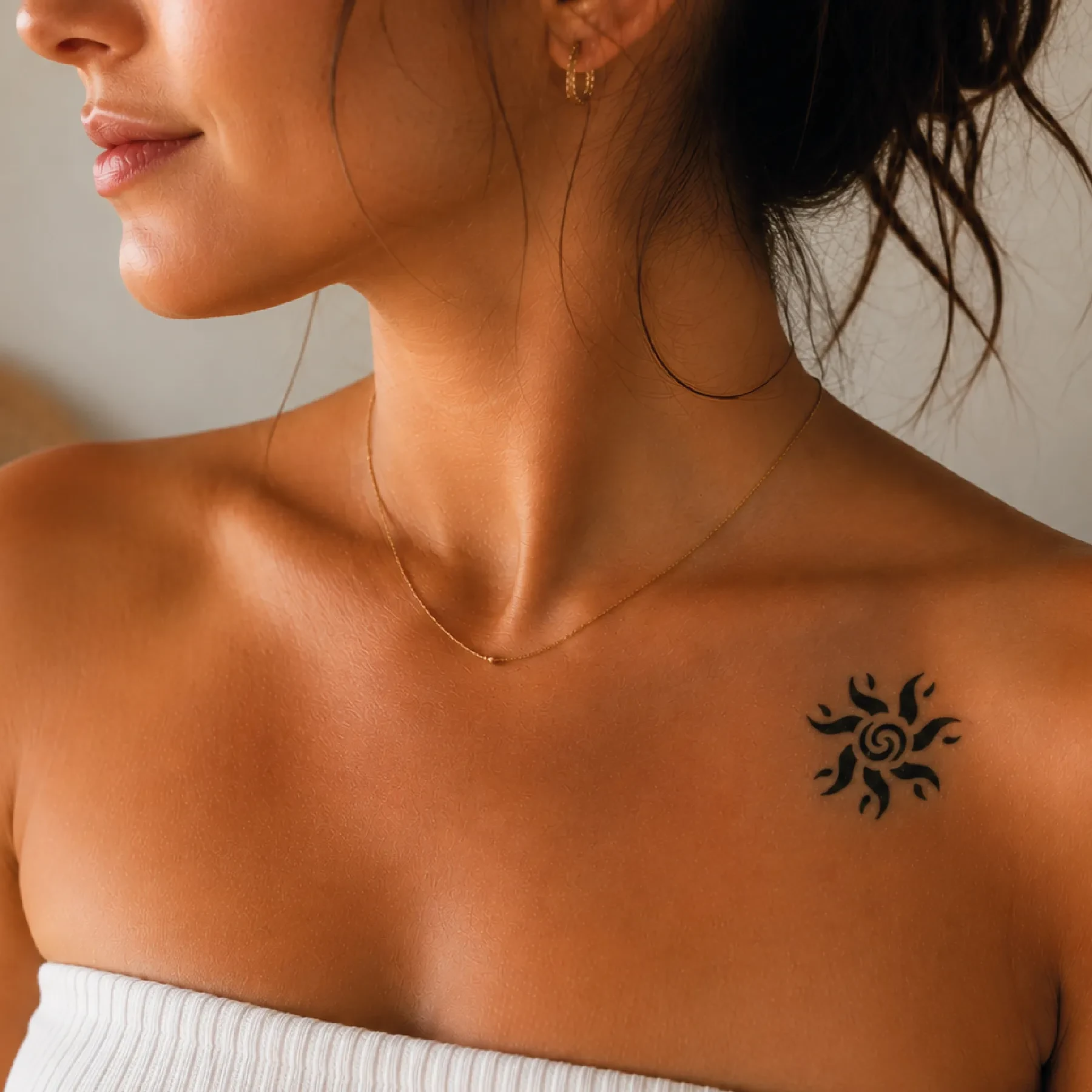 Jeune femme portant un tatouage éphémère Soleil Spirale Dynamique sur l'épaule près de la clavicule
