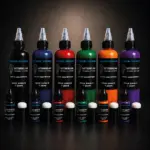 Collection d’encres à séchage rapide pour tatouage temporaire en noir, bleu, rouge, vert, orange et violet, disponibles en flacons de 10 ml et 100 ml.